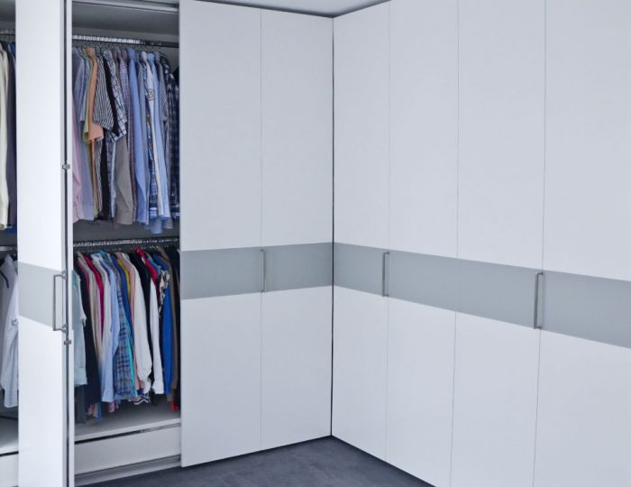 Schlafzimmerschrank übereck in MDF weiß mit Einlage in grau lackiert